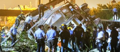 Rescue workers climb into the wreckage of a crashed Amtrak train in Philadelphia
